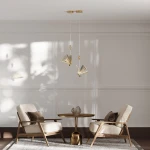 Lampa wisząca Mariposa 1xLED/8W w kolorze złotym z dekoracyjnymi elementami w kształcie wachlarzy. Zawieszona na cienkich linkach, umieszczona w jasnym wnętrzu z dwiema miękkimi fotelami i okrągłym stolikiem.