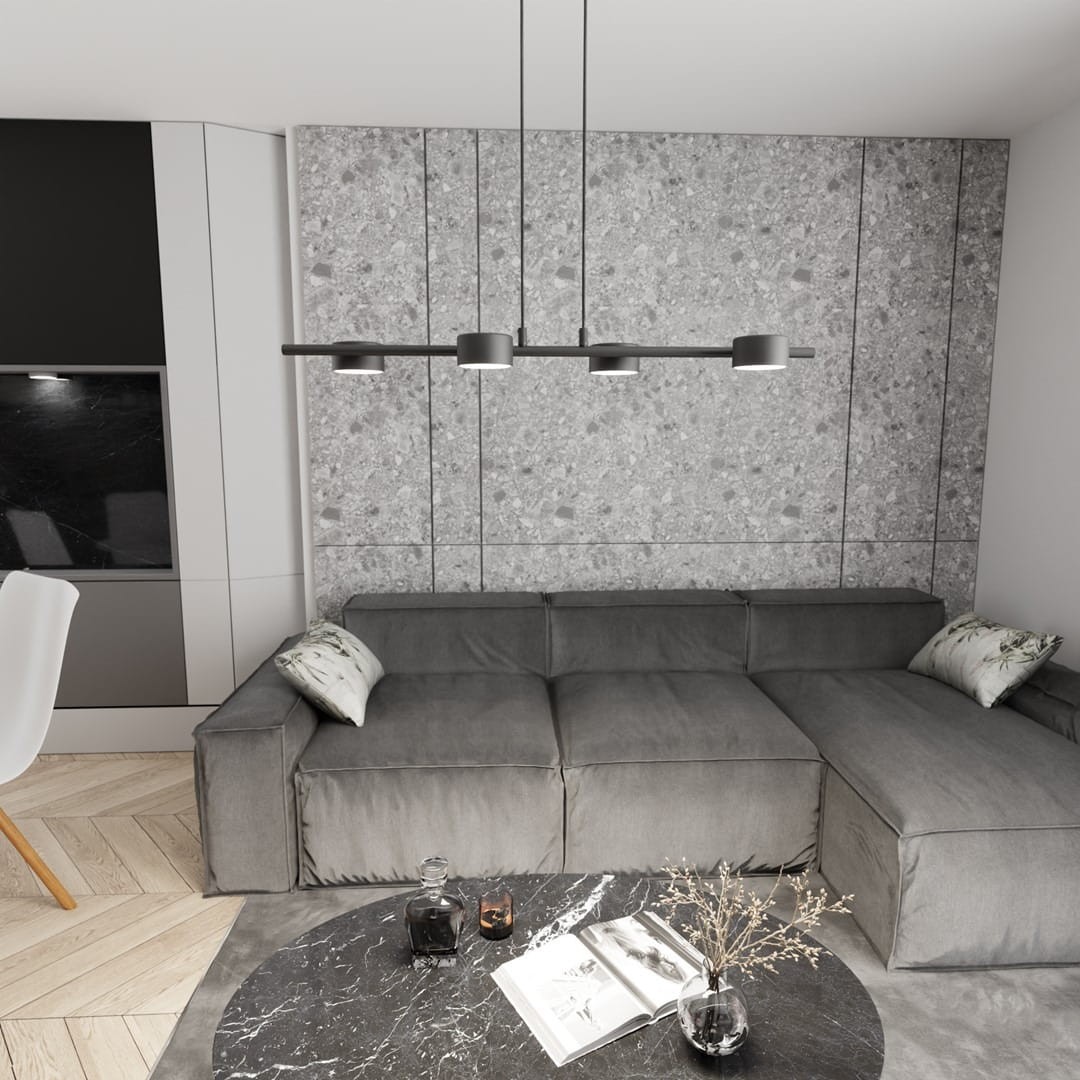 Lampa wisząca Sora czarna z czterema źródłami światła GX53, zawieszona nad szarym narożnym kanapą w nowoczesnym wnętrzu. Widoczna betonowa ściana w tle, stół z marmurowym blatem oraz dekoracje na stole.