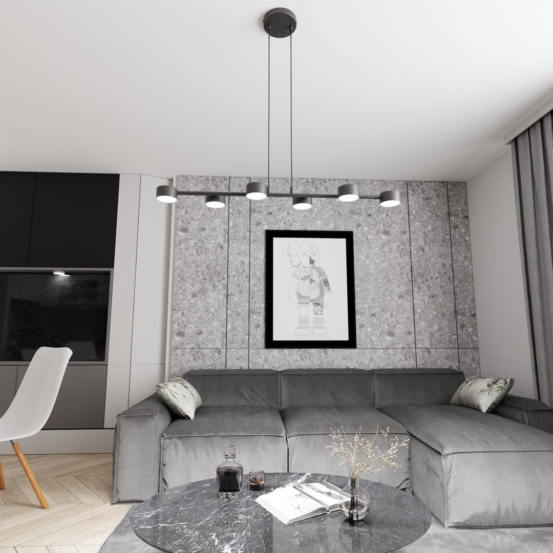 Lampa wisząca Megara z sześcioma źródłami światła GX53 w kolorze czarnym, zawieszona na długich linkach. Stylowy element oświetleniowy w nowoczesnym wnętrzu, z widoczną szaro-skalną ścianą i meblami w odcieniach szarości.