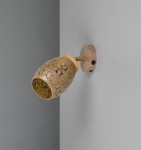 Kinkiet Bidar w kolorze kawowym z dekoracyjnym kloszem w formie owalnej z geometrycznym wzorem, zamocowany na ścianie. Lampa ma jedno gniazdo E14, umiejscowiona pod kątem, oferująca możliwość regulacji kierunku światła.