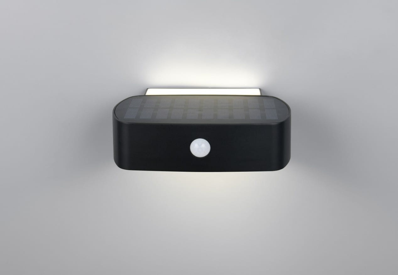 Kinkiet zewnętrzny Bilbao Hybrid w kolorze czarnym, z wbudowanym panelem solarnym i czujnikiem ruchu. Oświetlenie LED 1x6W, stopień ochrony IP44. Ujęcie frontalne, produkt zamontowany na ścianie, emitujący światło w dół.