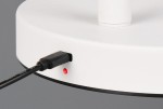 Biała lampa podłogowa Blake z portem USB, widok z boku. Na zdjęciu widoczny kabel podłączony do lampy oraz czerwony wskaźnik zasilania. Lampa ma okrągłą podstawę z czarną krawędzią.