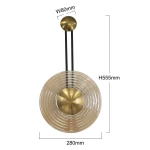 Kinkiet LED o mocy 8W w kolorze złotym i bursztynowym. Okrągła, teksturowana oprawa o średnicy 280 mm i wysokości 555 mm, zawieszona na czarnych linkach. Widoczny metalowy uchwyt o średnicy 80 mm.