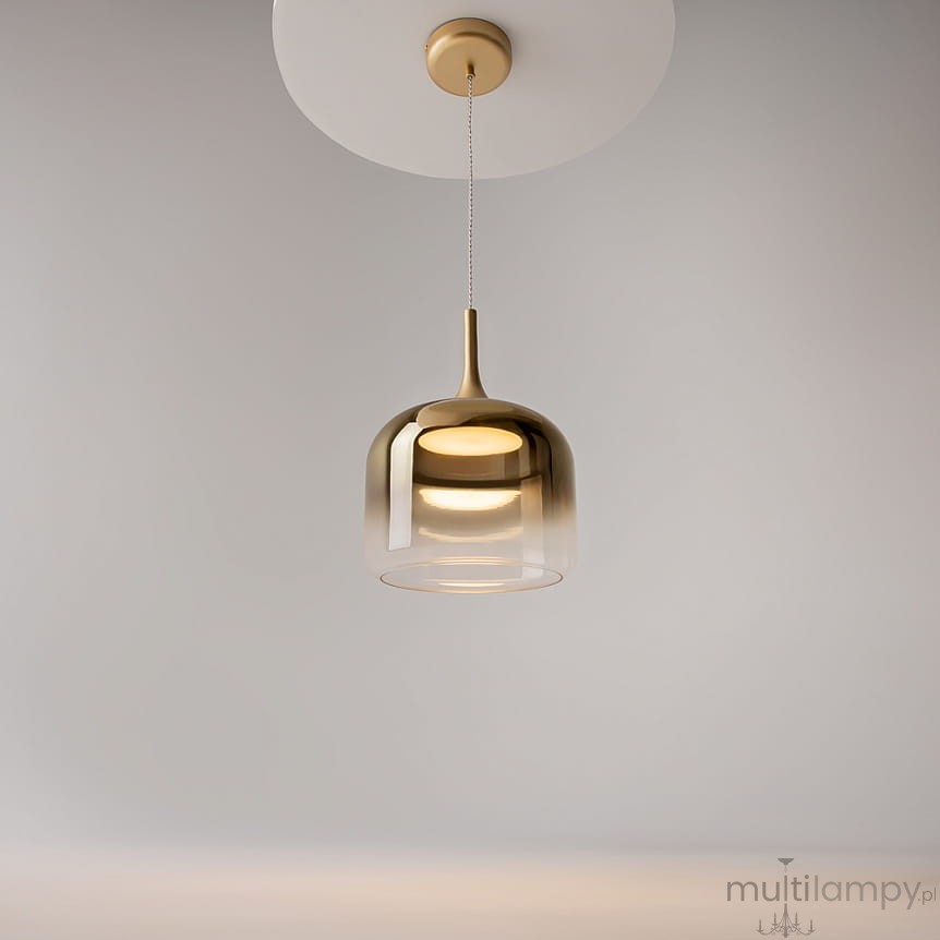 Lampa wisząca LED Spirito o mocy 12W w złotym kolorze, z półprzezroczystym kloszem o zaokrąglonym kształcie, zawieszona na cienkim przewodzie, z widoczną podstawą montażową w kolorze białym, na jednolitym tle.
