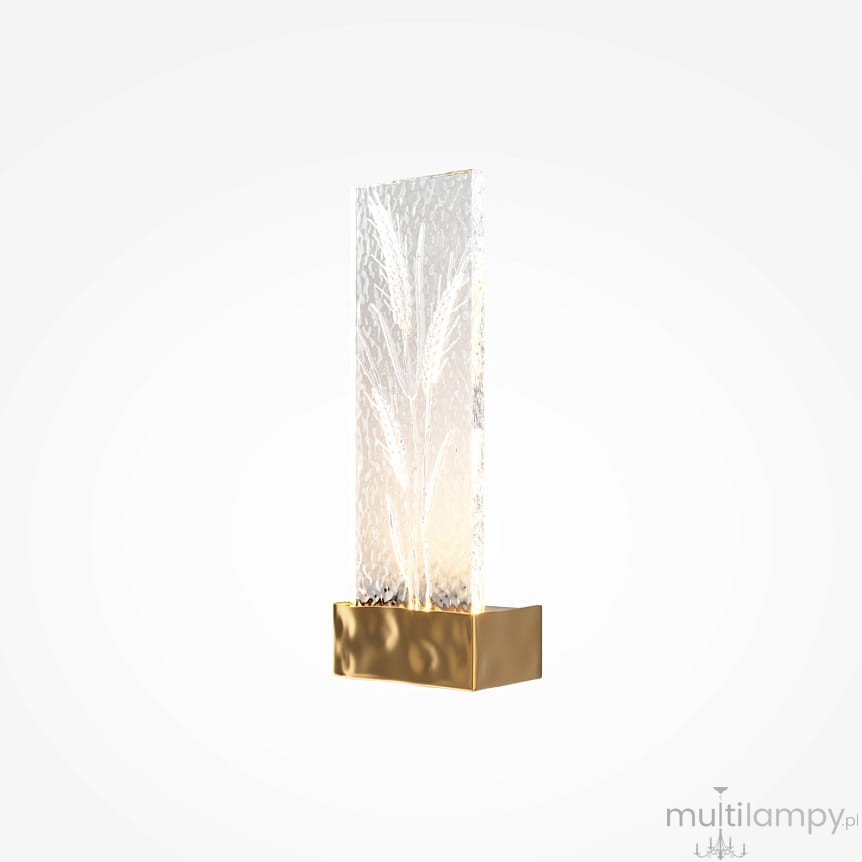 Kinkiet LED/2W w mosiężnej podstawie, z przezroczystym panelem o fakturze szkła, z delikatnym wzorem roślinnym. Wykończony w eleganckim stylu, montowany na ścianie, emitujący ciepłe światło. Tło białe, minimalistyczne.