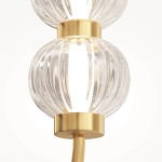 Lampa wisząca LED Amulet o mocy 16W, z złotą podstawą i dwoma przezroczystymi, falistymi kloszami. Ujęcie z przodu, pokazujące detale kloszy oraz metalowej oprawy. Tło jasne, minimalistyczne.