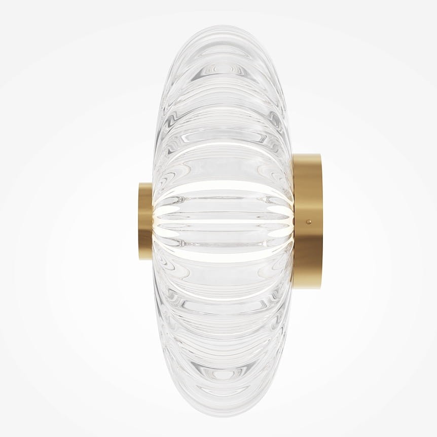 Kinkiet LED Amulet o mocy 8W, w złotej oprawie, z przezroczystym, teksturowanym kloszem, o okrągłym kształcie. Produkt zamontowany na ścianie, prezentujący nowoczesny design. Tło jasne, jednolite.