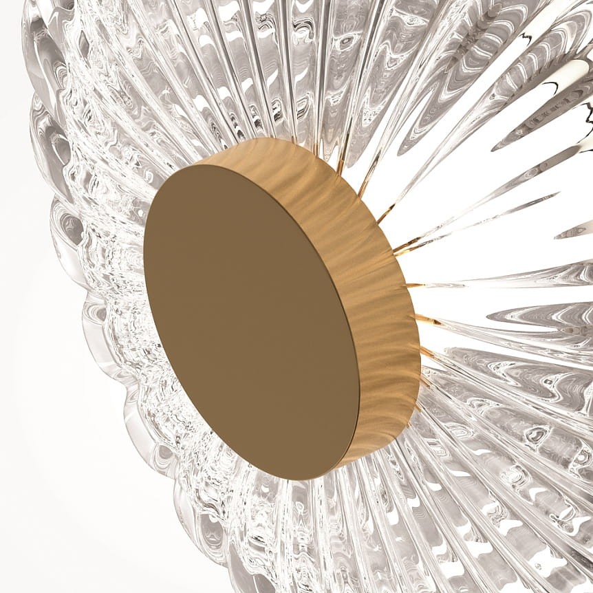 Lampa stołowa LED Amulet o mocy 10W w kolorze złotym. Posiada okrągłą podstawę z matowego metalu oraz przezroczystą, teksturowaną klosz z detalami przypominającymi fale. Widok z boku ukazuje elegancki design i strukturę materiału.