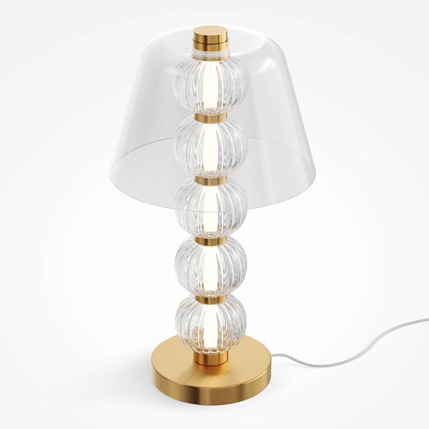 Lampa stołowa LED 10W w kolorze złotym z przezroczystym kloszem. Posiada sześć szklanych kul, które tworzą efektowną konstrukcję. Ustawiona na okrągłej podstawie, z przewodem elektrycznym widocznym z boku.