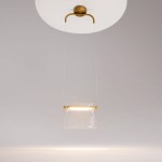 Lampa wisząca Cabaret LED o mocy 8W, wykonana z mosiądzu, z przezroczystym kloszem w kształcie stożka. Zawieszona na cienkich linkach, umieszczona pod okrągłym, metalowym mocowaniem. Emituje ciepłe światło, idealna do nowoczesnych wnętrz.