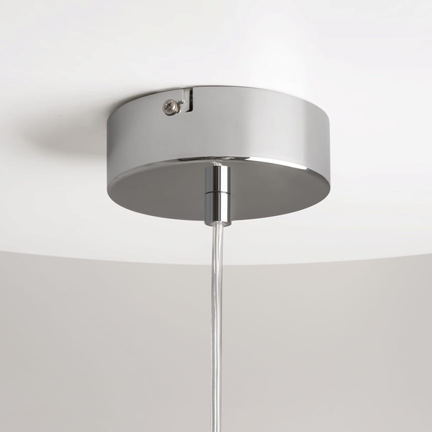 Lampa wisząca Drop z chromowaną podstawą i przezroczystym kablem. Ujęcie z dołu, pokazujące mocowanie oraz detal chromowanego wykończenia. Prosta, okrągła forma, idealna do nowoczesnych wnętrz.
