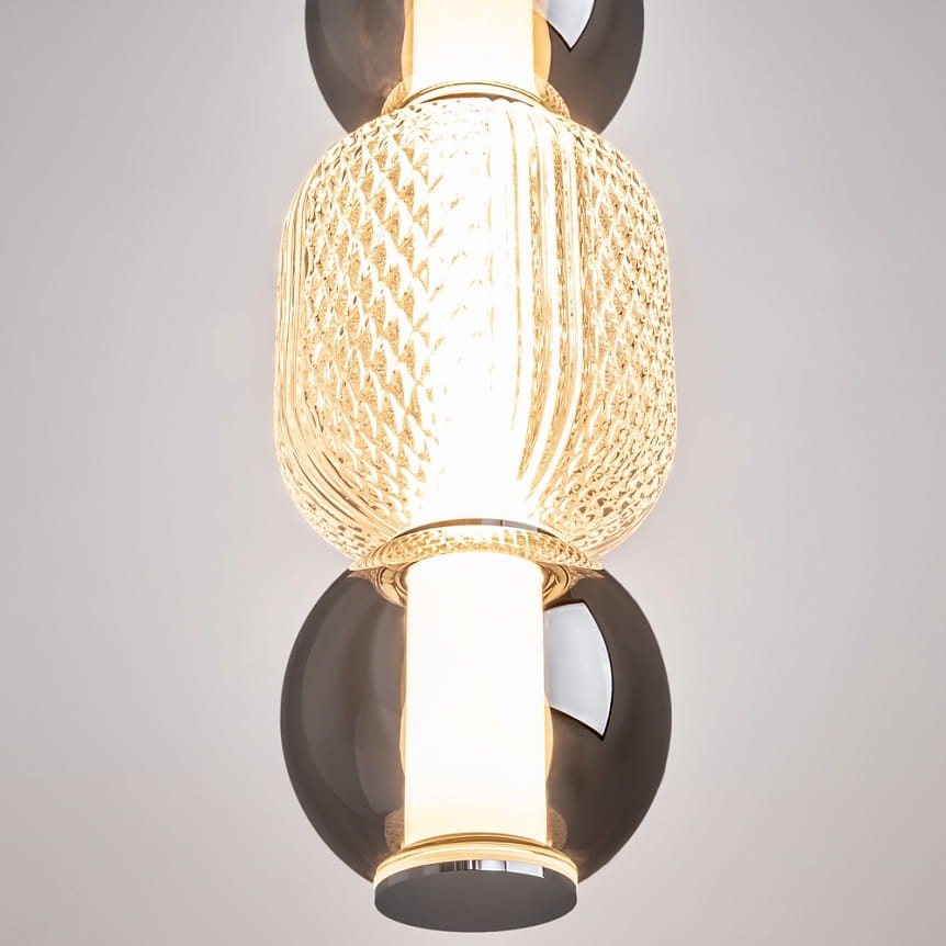 Lampa wisząca Drop z chromowanym wykończeniem, zbudowana z elementów szklanych w kolorze przezroczystym i dymnym. Posiada jeden źródło światła LED o mocy 16W, o okrągłym kształcie z dekoracyjnym, teksturowanym kloszem.