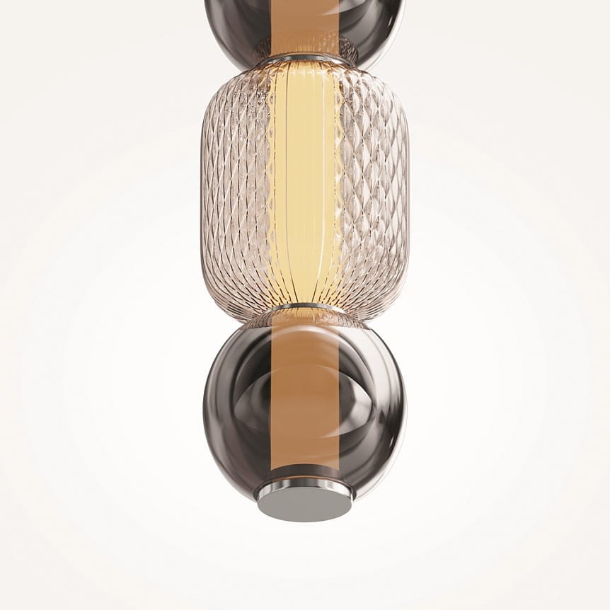 Lampa wisząca Drop z chromowanym wykończeniem, z jedną żarówką LED 16W. Szklany klosz o kształcie cylindrycznym z teksturą diamentową, w odcieniu brązowym, z centralnym źródłem światła. Zawieszona w pozycji pionowej, na jasnym tle.