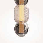Lampa wisząca Drop z chromowanym wykończeniem, z jedną żarówką LED 16W. Szklany klosz o kształcie cylindrycznym z teksturą diamentową, w odcieniu brązowym, z centralnym źródłem światła. Zawieszona w pozycji pionowej, na jasnym tle.