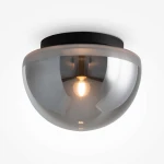 Lampa sufitowa Glassy z kloszem w dymionym szkle, z czarnym metalowym mocowaniem. Okrągły kształt, widoczna żarówka E27 wewnątrz, w ujęciu frontalnym, zamontowana na suficie. Tło jasne, jednolite.