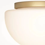 Lampa sufitowa Glassy 1xE27 w kolorze złotym i białym, z okrągłym kloszem z mlecznego szkła i metalową, złotą oprawą. Ujęcie z bliska, pokazujące detal klosza i elementy mocujące.