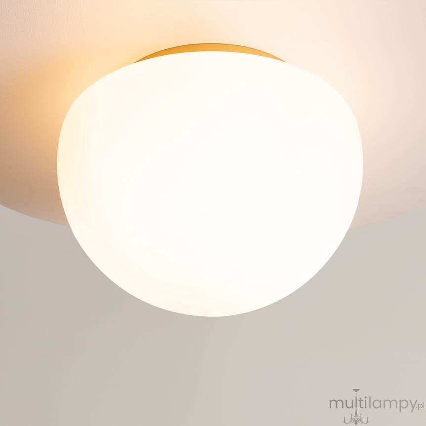 Lampa sufitowa Glassy z kulistym kloszem w kolorze białym i złotą podstawą. Ujęcie z bliska pokazujące gładką, matową powierzchnię klosza. Lampa zamontowana na suficie, emanująca miękkie światło. Idealna do nowoczesnych wnętrz.