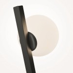 Kazimir kinkiet 1xG9 w kolorze czarnym, o prostokątnym kształcie, zamontowany na okrągłej podstawie. Emituje światło z białą, matową kloszową osłoną. Zdjęcie z perspektywy bocznej, ukazujące detale wzornictwa i materiału.