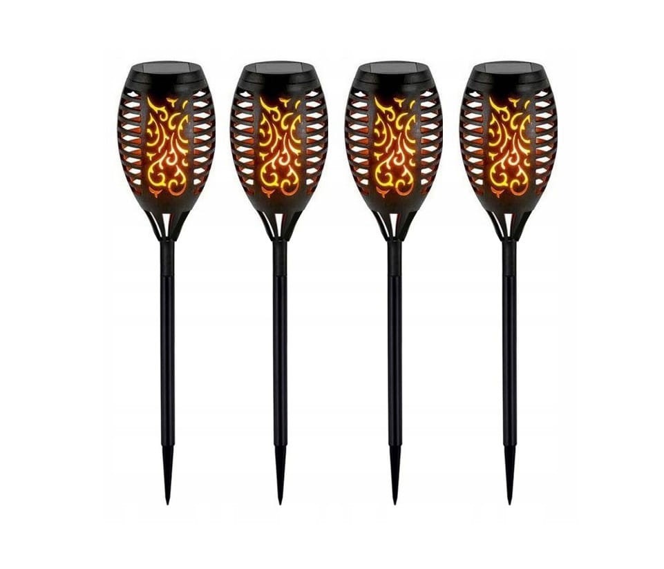 Cztery czarne lampy solarne ogrodowe w kształcie pochodni, wbijane w ziemię. Posiadają dekoracyjne, ażurowe wzory oraz LED-owe światło w odcieniach pomarańczowego. Stoją w pionie, idealne do oświetlenia ogrodu. Wysokość 50 cm.
