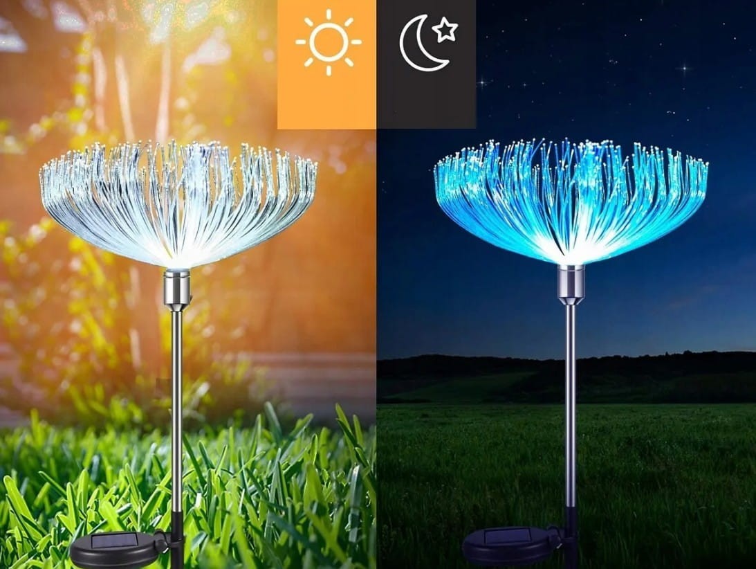 Dwie lampy solarne ogrodowe Dmuchawiec RGB o wysokości 74 cm, z elastycznymi, świecącymi włóknami LED w kształcie dmuchawca. Umieszczone na metalowych stelażach, działają w dzień i w nocy, emitując kolorowe światło.