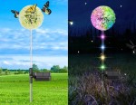 Lampa solarna ogrodowa Mniszek z LED, w kształcie kwiatu, wbijana w ziemię. Biała główka z kolorowymi diodami, metalowy stelaż. Widoczny panel solarny, używana na zewnątrz w dzień i w nocy, tworzy efektowne podświetlenie.