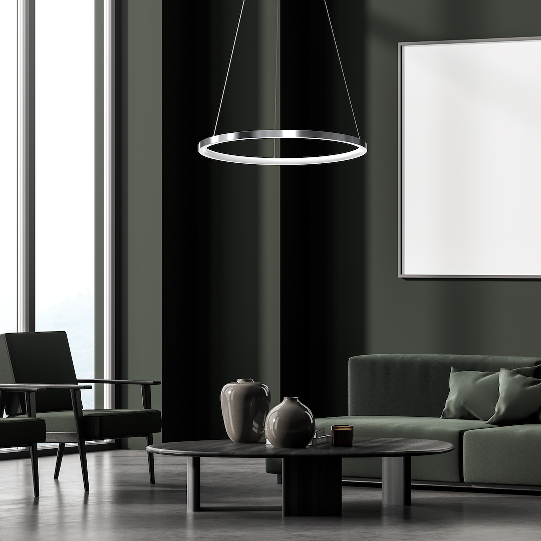 Lampa wisząca LED Hoop o mocy 27W w chromowanej obudowie, zawieszona na cienkich linkach. W tle nowoczesny salon z zielonymi kanapami i stołem kawowym. Ściany w ciemnym kolorze, duże okna zapewniające naturalne światło.