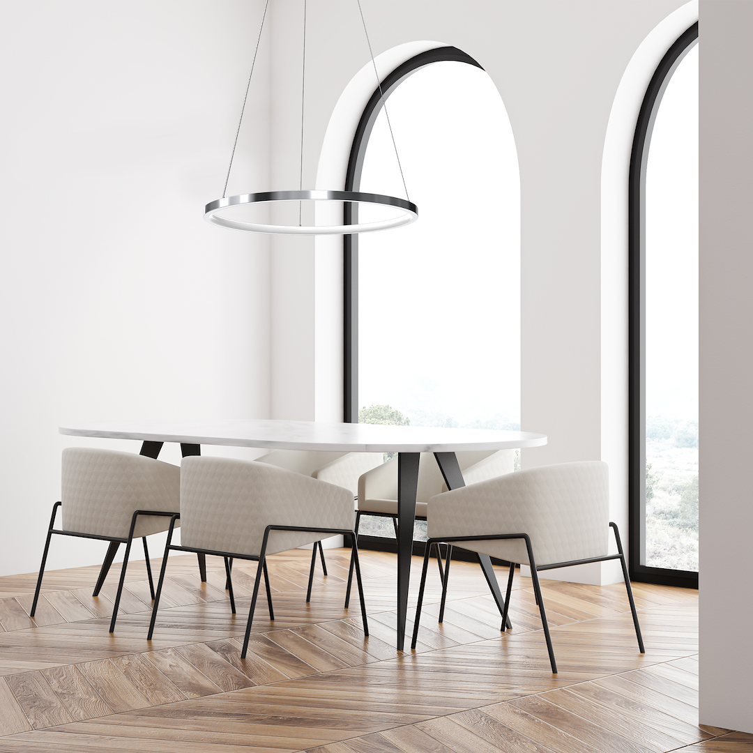 Lampa wisząca LED Hoop 27W w chromowanym wykończeniu, okrągły kształt, zawieszona nad białym stołem w jasnym wnętrzu. W otoczeniu czterech beżowych krzeseł na drewnianej podłodze, duże okna w tle.