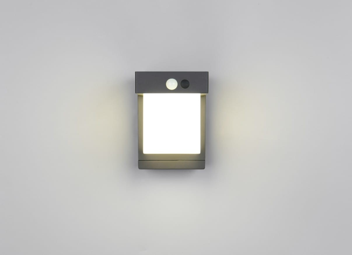 Kinkiet zewnętrzny Colombo Hybrid w kolorze czarnym, z panelem solarnym i 1xLED o mocy 5,5W. Prosty, kwadratowy kształt z czujnikiem ruchu. Zainstalowany pionowo, na jednolitym tle, idealny do oświetlenia przestrzeni zewnętrznych.