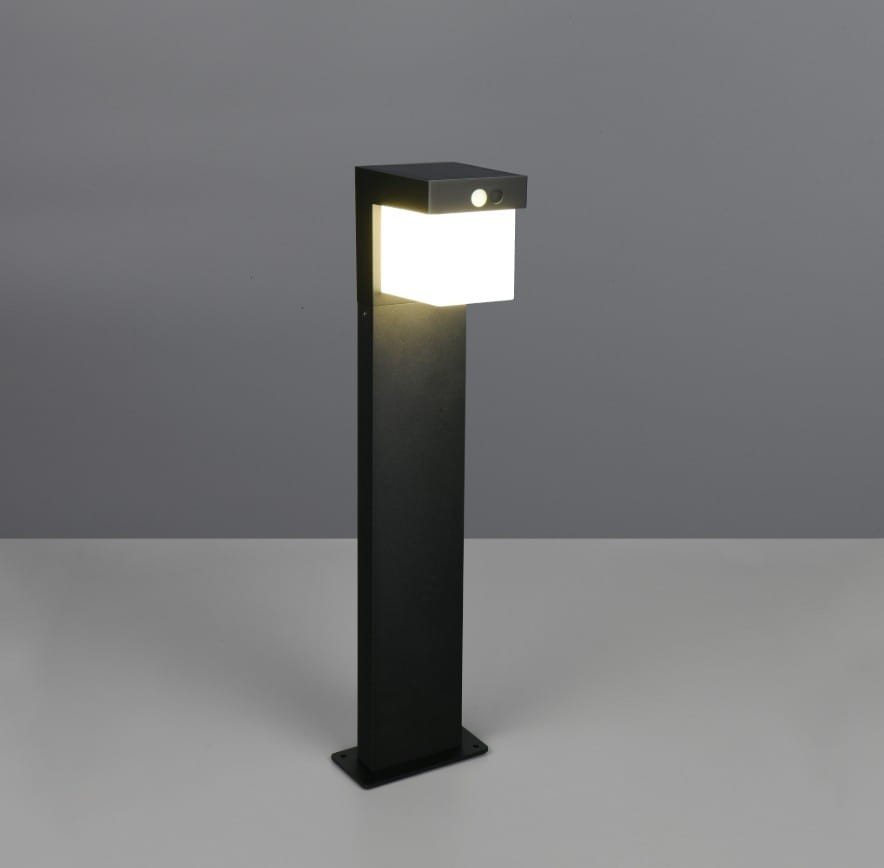 Lampa stojąca ogrodowa Colombo Hybrid H50 w kolorze czarnym, z prostokątną głowicą, emitującą ciepłe światło LED. Wysoka na około 1 metr, z wbudowanym czujnikiem, wykonana z materiałów odpornych na warunki atmosferyczne (IP44).