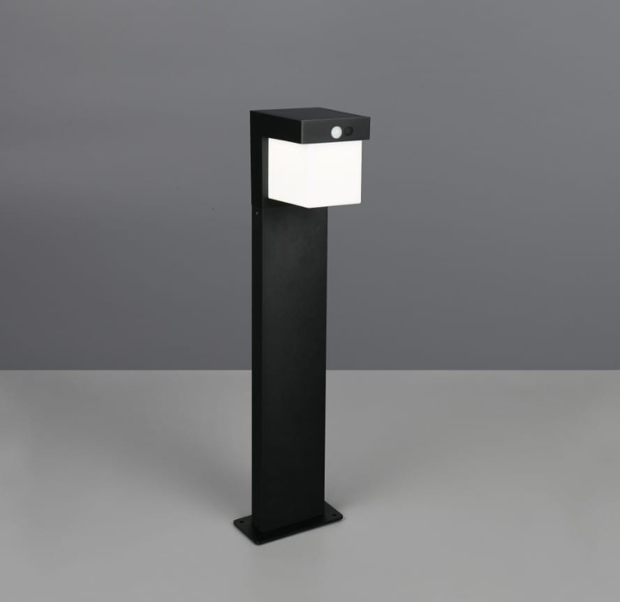 Lampa stojąca ogrodowa Colombo Hybrid H50 w kolorze czarnym, z prostokątną białą głowicą, wykonana z materiałów odpornych na warunki atmosferyczne. Posiada zamontowany czujnik. Ujęcie frontalne, produkt stoi na płaskiej powierzchni.