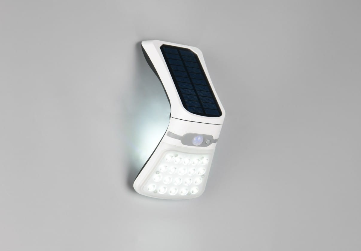 Kinkiet zewnętrzny Diadema, biały, z panelem solarnym i czujnikiem ruchu oraz zmierzchu. Zainstalowany na ścianie, z przodu widoczna lampa LED z 24 diodami. Kształt zaokrąglony, z gładką powierzchnią. Wyposażony w przycisk włączania.