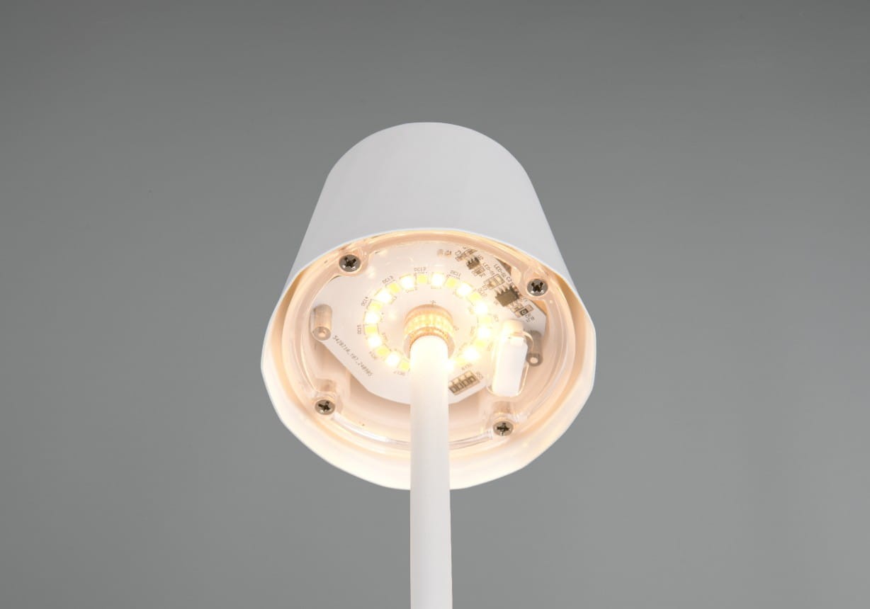 Lampa stołowa zewnętrzna Diaz w kolorze białym, widok od dołu. Na zdjęciu widoczne diody LED oraz elementy elektroniczne na podstwie. Lampa ma prosty, cylindryczny kształt z białą obudową i wbudowane źródło światła o mocy 1,6W.