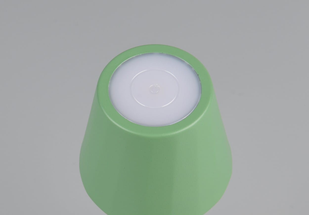 Zielona lampa stołowa zewnętrzna Diaz, z LED o mocy 1,6 W i regulacją temperatury barwowej (CCT). Ujęcie z góry, pokazujące zaokrąglony kształt i białą, okrągłą szybę na górze. Matowa powierzchnia, bez dodatkowych zdobień.