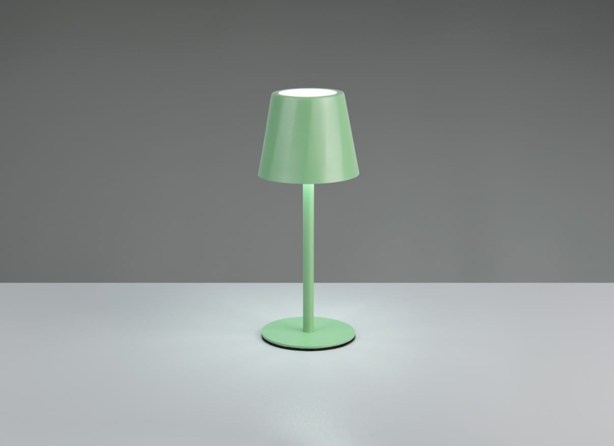 Zielona lampa stołowa zewnętrzna Diaz z kloszem w kształcie stożka, umieszczona na okrągłej podstawie. Wyposażona w jedno źródło LED o mocy 1,6W, świeci delikatnym światłem. Ujęcie frontalne, produkt stoi na jasnym blacie.