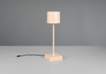 Lampa stołowa zewnętrzna Fernandez w kolorze piaskowym, z cylindrycznym kloszem na smukłym stelażu. Ustawiona na kwadratowej podstawie, z widocznym kablem zasilającym. Idealna do oświetlenia przestrzeni na świeżym powietrzu.