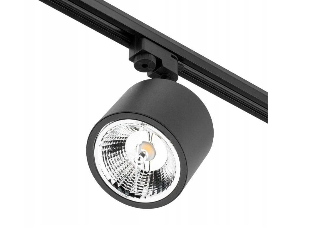 Reflektor spot GU10 AR111 w kolorze czarnym, zamontowany na szynie 1-fazowej. Okrągła głowica z metaliczną osłoną, widoczna żarówka w centrum. Kąt ujęcia z boku, ukazujący detale konstrukcji.