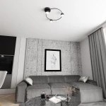 Lampa sufitowa Lucio 3xGX53 w kolorze czarnym, zamontowana na suficie. Posiada okrągłą konstrukcję z trzema źródłami światła o białym kloszu. Tło z szarymi panelami i kanapą w odcieniach szarości.