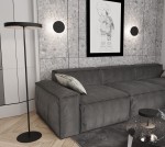 Lampa stołowa Nemo w kolorze czarnym, z metalowym stelażem i okrągłym kloszem, umieszczona obok szarej sofy. W tle widoczna szara ściana z dekoracyjnymi detalami i czarne elementy oświetlenia.