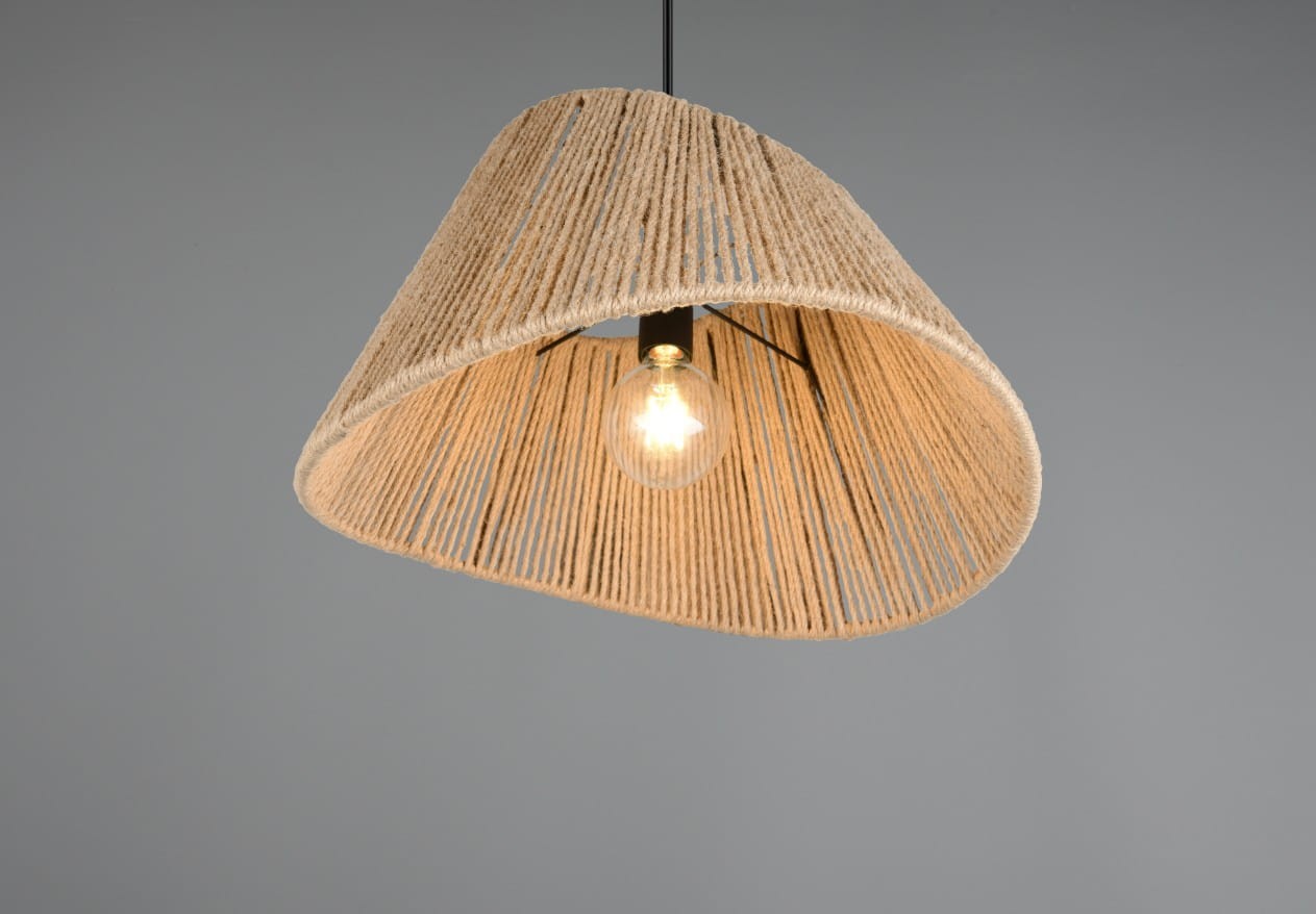 Lampa wisząca Valerie z kloszem w kolorze naturalnym, wykonanym z plecionego materiału, z widoczną żarówką E27. Klosz ma asymetryczny kształt, zawieszony na czarnym przewodzie, na jednolitym, szarym tle.
