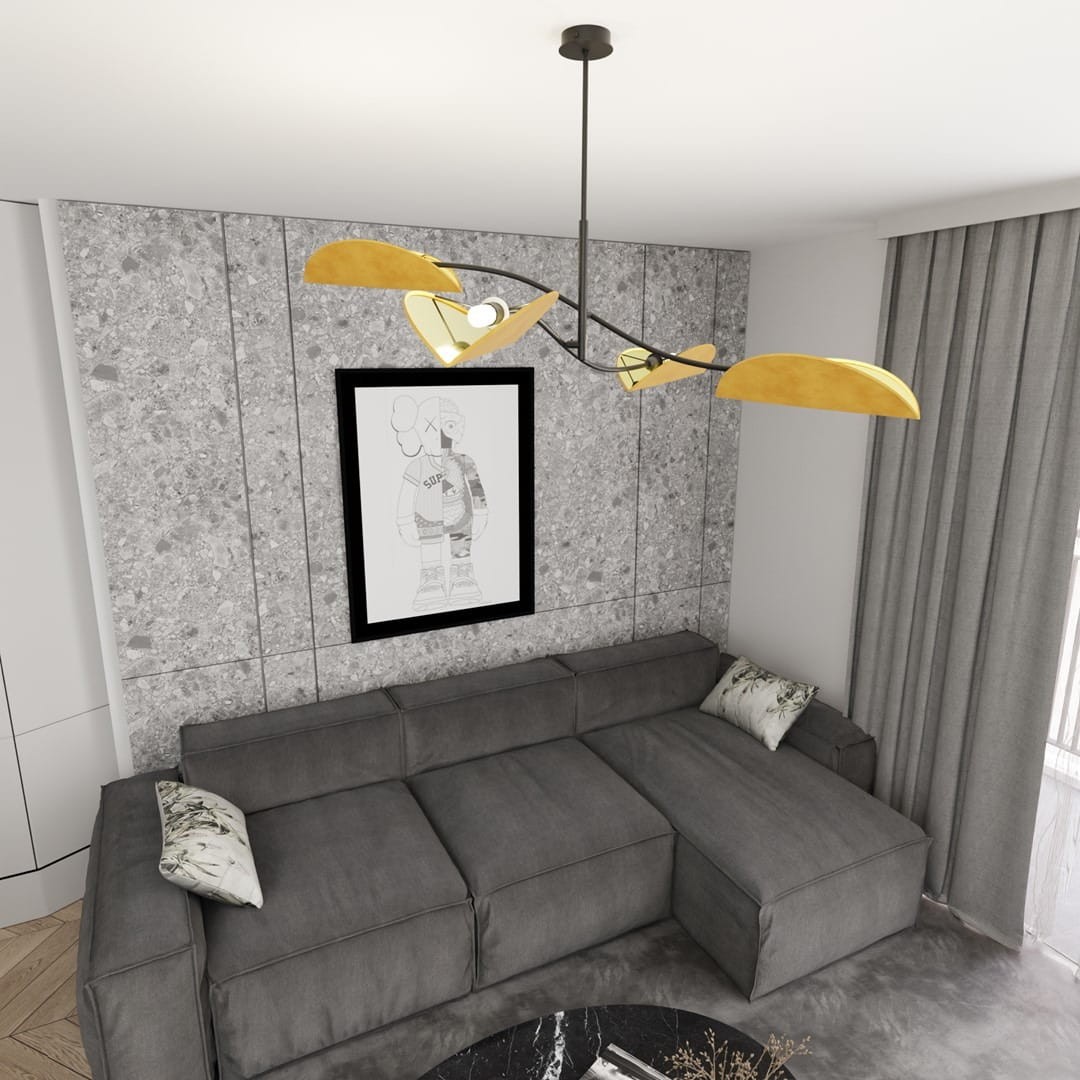 Czarna lampa sufitowa Lotus z czterema kloszami E14 w kształcie liści, w kolorze pomarańczowym, zawieszona nad szarym rogowym narożnikiem. W tle widoczna szara ściana z grafiką oraz zasłony.