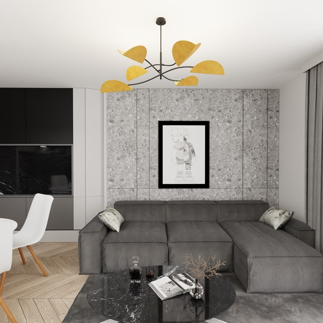 Lampa sufitowa Lotus w kolorze czarnym i pomarańczowym z sześcioma źródłami światła E14. Ujęcie z dołu, z widocznymi stylizowanymi, pomarańczowymi kloszami w kształcie liści. Lampa zawieszona w nowoczesnym wnętrzu z szarymi ścianami i eleganckim sofą.