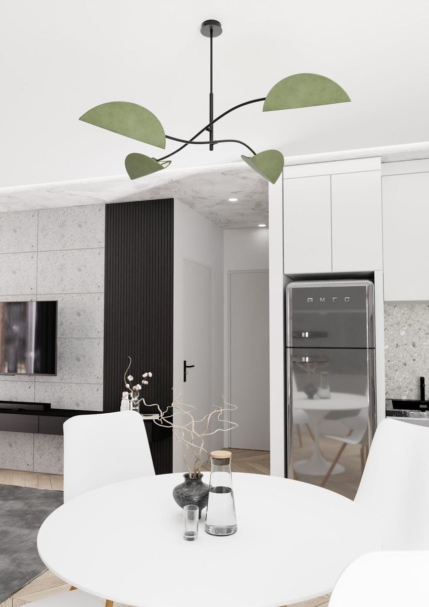 Czarna lampa sufitowa Lotus z zielonymi kloszami, zawieszona na cienkim, czarnym przewodzie. Klosze mają półokrągły kształt, a lampa znajduje się w nowoczesnym wnętrzu z białymi meblami i szarym dywanem, na tle ściany z płyt betonowych.