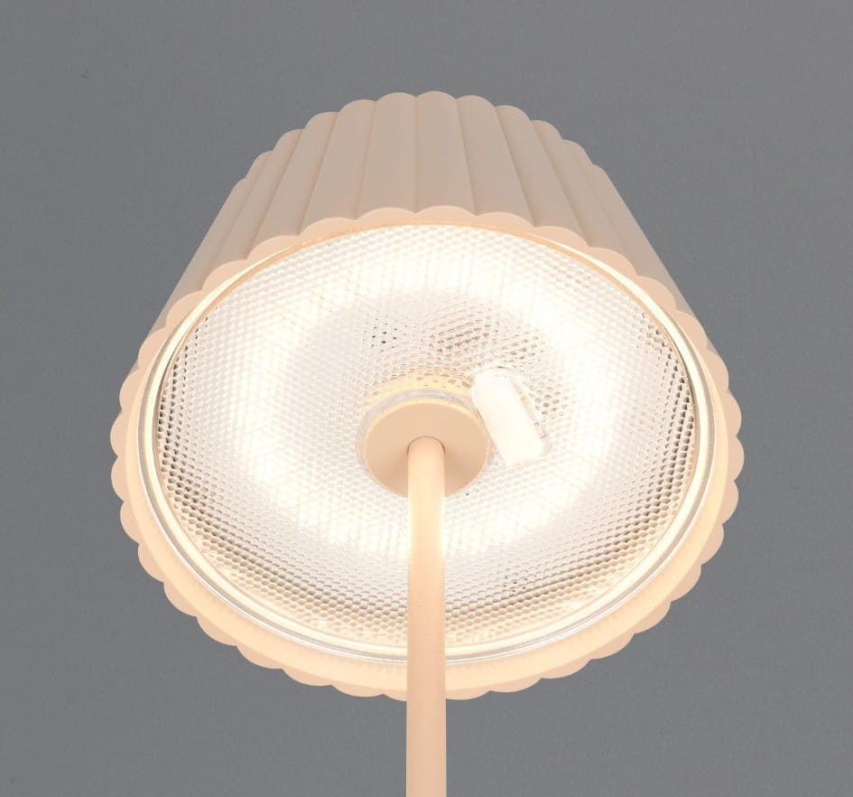 Lampa stojąca zewnętrzna Suarez w kolorze piaskowym, z kloszem o falistym kształcie i poświatą LED. Widok z góry na klosz i źródło światła. Klosz wykonany z przezroczystego materiału, podstawa prosta, elegancka.