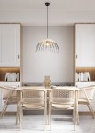 Lampa wisząca Sandrine w kolorze czarnym i naturalnym, z kloszem w kształcie półkuli, zawieszona na cienkim przewodzie. Produkt znajduje się nad drewnianym stołem w minimalistycznej aranżacji wnętrza, z widocznymi krzesłami i regałem w tle.