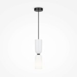 Lampa wisząca Memory z pojedynczym źródłem światła E14, z białym kloszem o cylindrycznym kształcie. Utrzymana w minimalistycznym stylu, zawieszona na czarnym przewodzie, z metalowym mocowaniem na suficie. Tło białe.