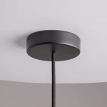Lampa wisząca Memory z metalowym, okrągłym mocowaniem w kolorze czarnym, zawieszona na tekstylnym przewodzie. Widoczna konstrukcja z górnej perspektywy, przeznaczona do żarówki E14. Tło jasne, jednolite.