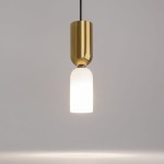 Lampa wisząca Memory w kolorze złotym z jedną oprawą na żarówkę E14. Posiada cylindryczny, błyszczący klosz u góry oraz matowy, szklany klosz na dole, emitujący ciepłe światło. Zawieszona na czarnym przewodzie, w minimalistycznym stylu.