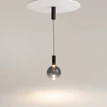 Lampa wisząca Nebula D20 z czarnym wykończeniem, z pojedynczym źródłem światła LED 4W. Okrągła, szklana kula zawieszona na cienkim przewodzie, montowana do białej podsufitki. Prosta forma w nowoczesnym stylu.