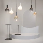 Lampa wisząca Nebula D20 w białej obudowie, z pojedynczym źródłem światła LED 4W. Okrągła, szklana kula w różnych odcieniach, zawieszona na cienkim przewodzie. W tle minimalistyczna aranżacja z czarnymi stolikami i białymi elementami.