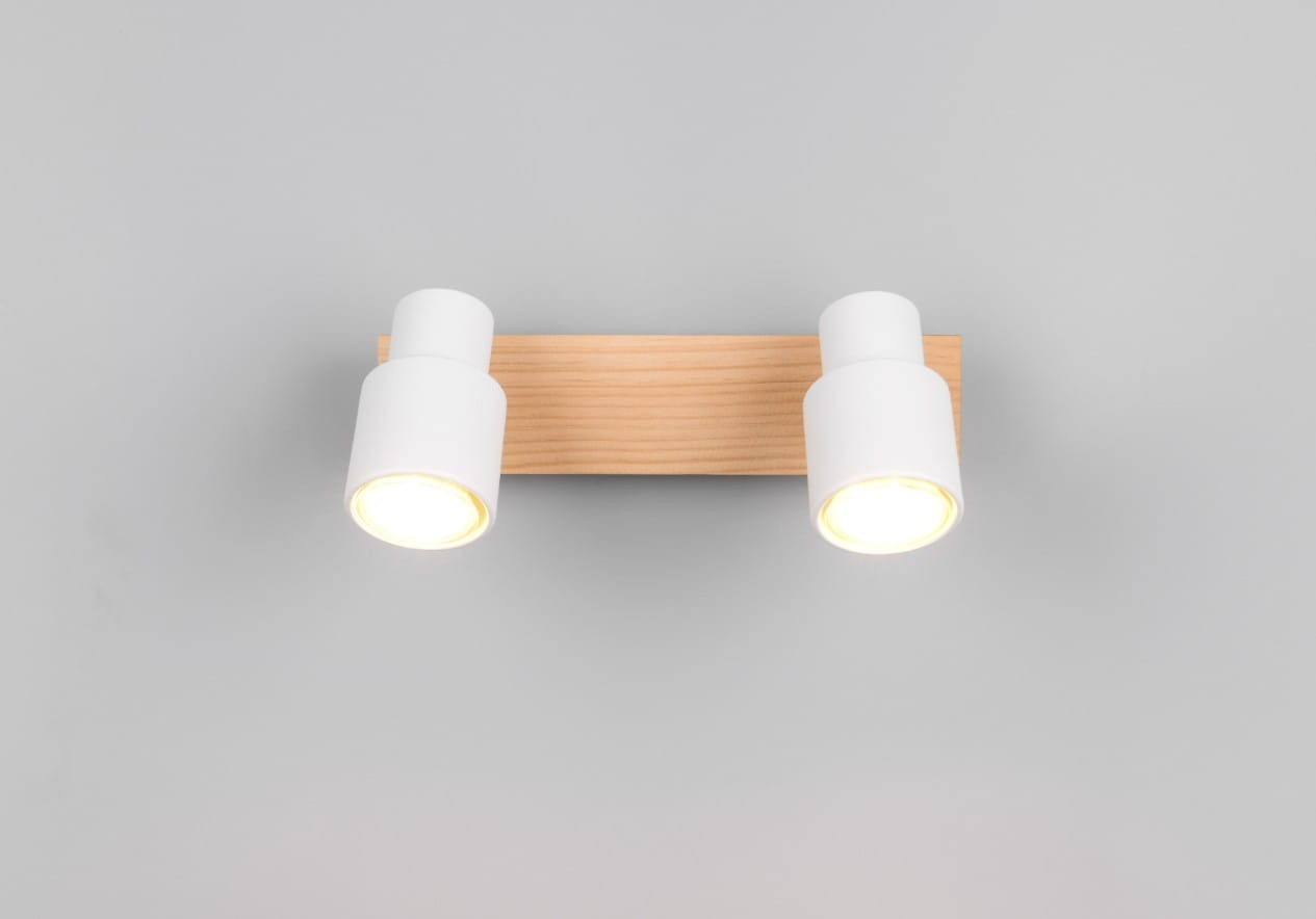 Lampa sufitowa Pierre z dwoma reflektorami GU10. Biała obudowa z jasnego drewna, zamontowana na prostokątnej podstawie. Reflektory ustawione równolegle, emitujące ciepłe światło. Ujęcie frontalne na szarym tle.